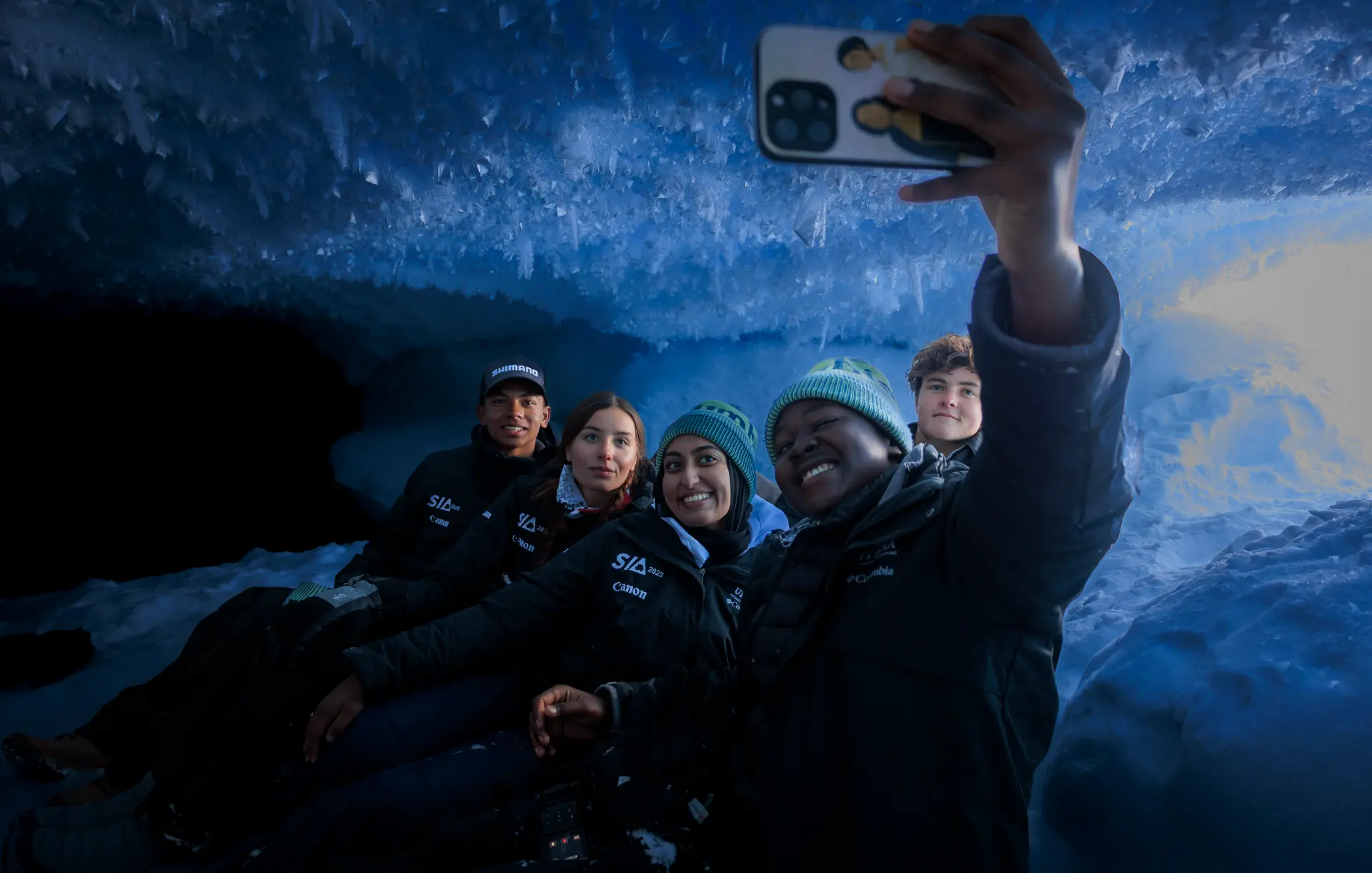 Five students taking a selfie inside a blue ice cave in Antarctica