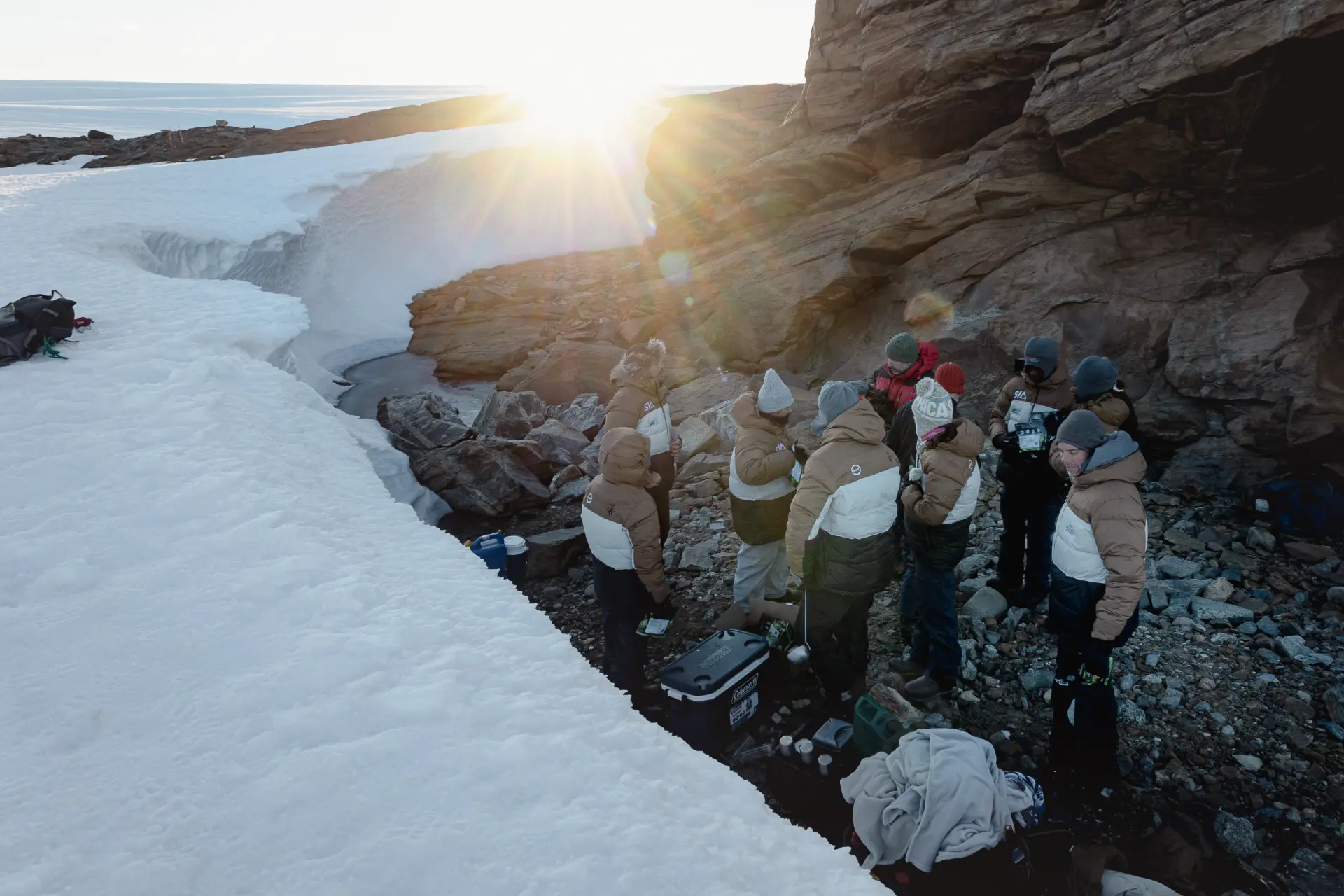 The expedition team gathered in a sheltered rocky alcove in Antarctica
