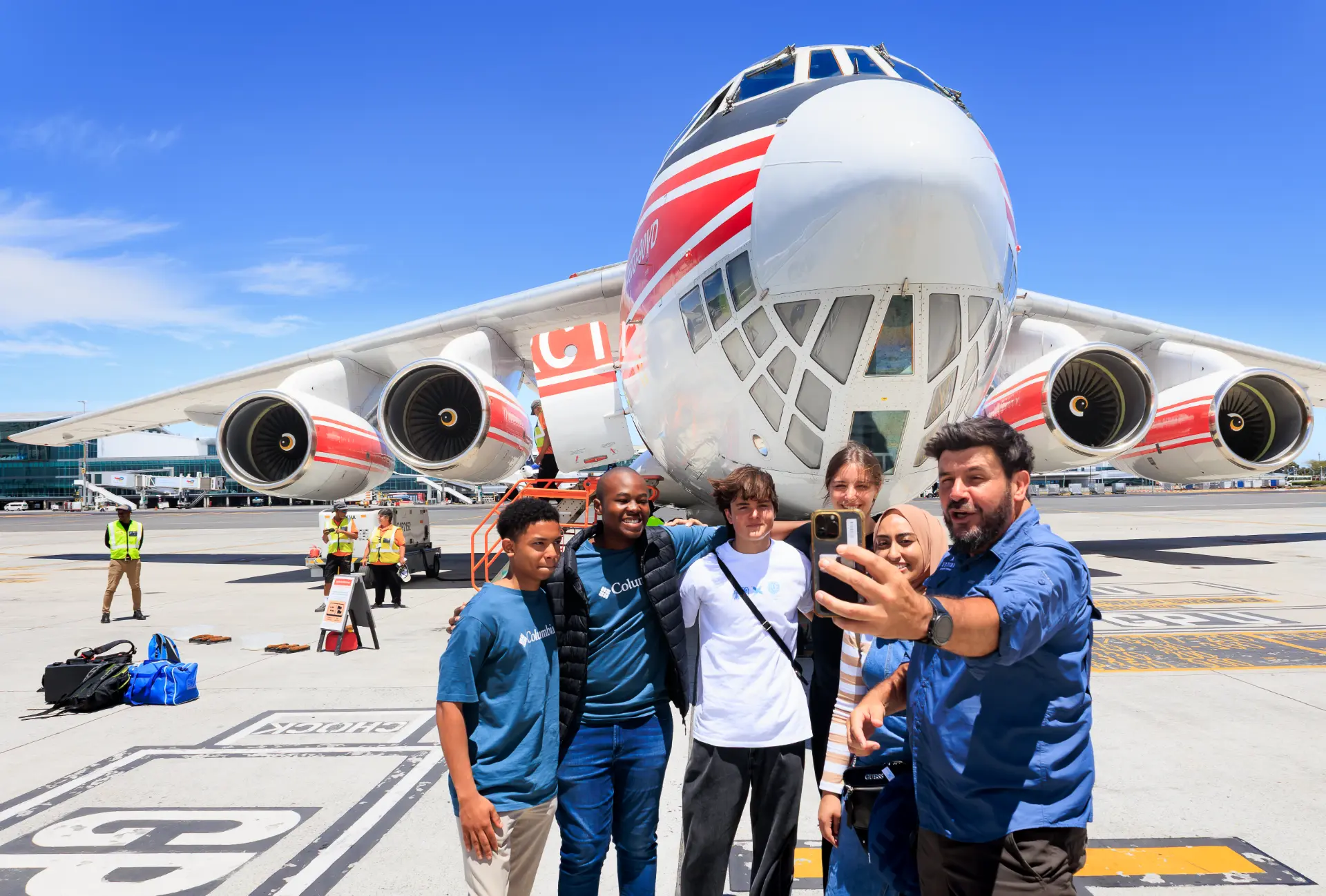Students taking a selfie with Riaan Manser in front of the IL-76 aircraft in Cape Town before departure